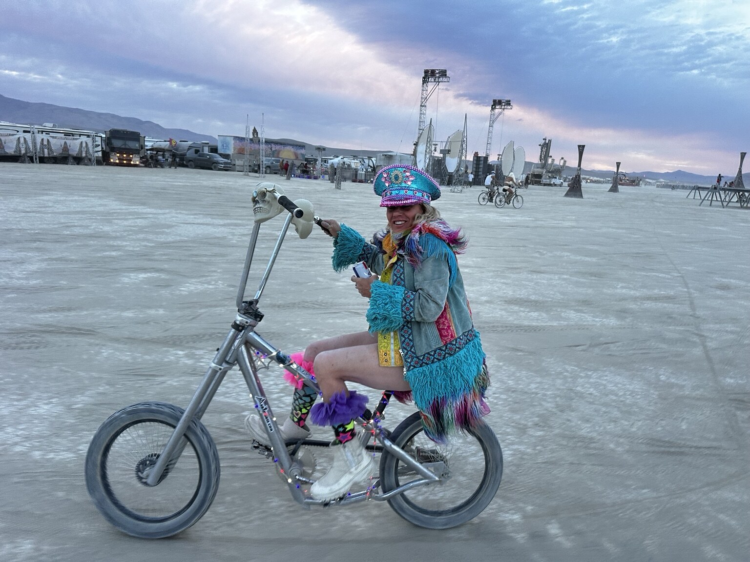 Allison Wicks riding a decorated bicycle at Burning Man