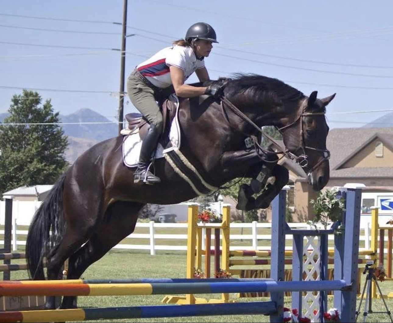 Allison Wicks riding a dark horse over a fence